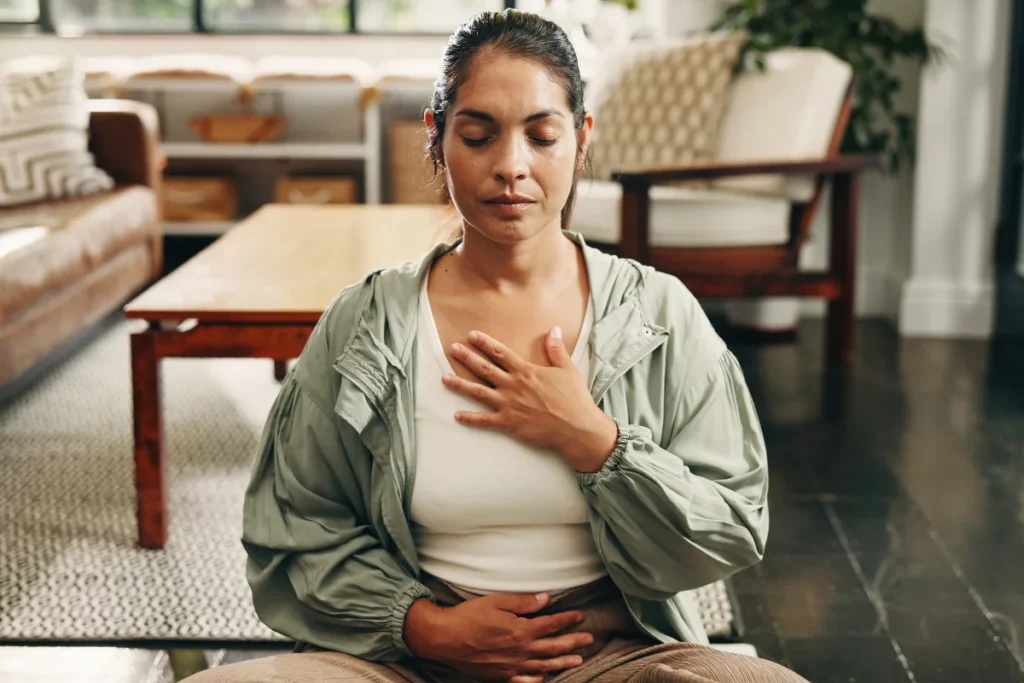 Woman calmly practicing diaphragmatic breathing to help regulate a sensitized nervous system