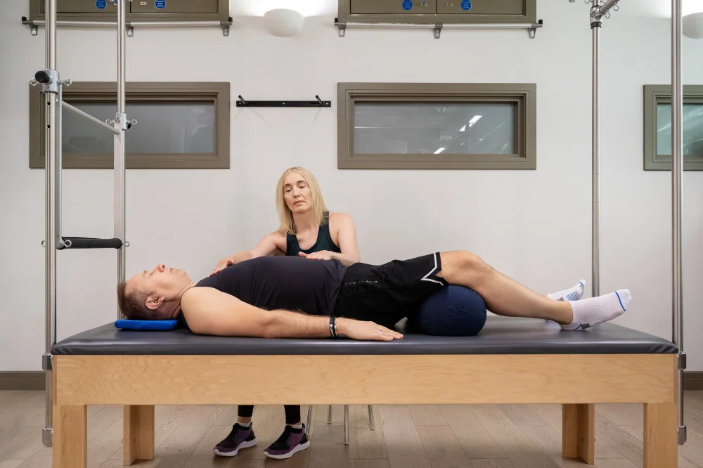 Jeannie Di Bon places her hands on a client helping them work on te breath